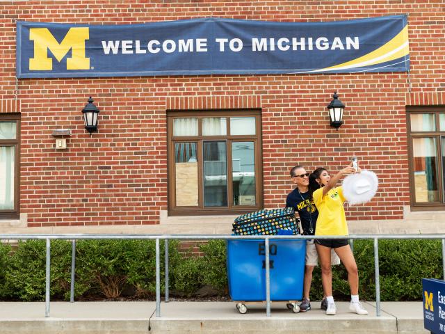 A parent and student take a selfie during Michigan Move-In. 