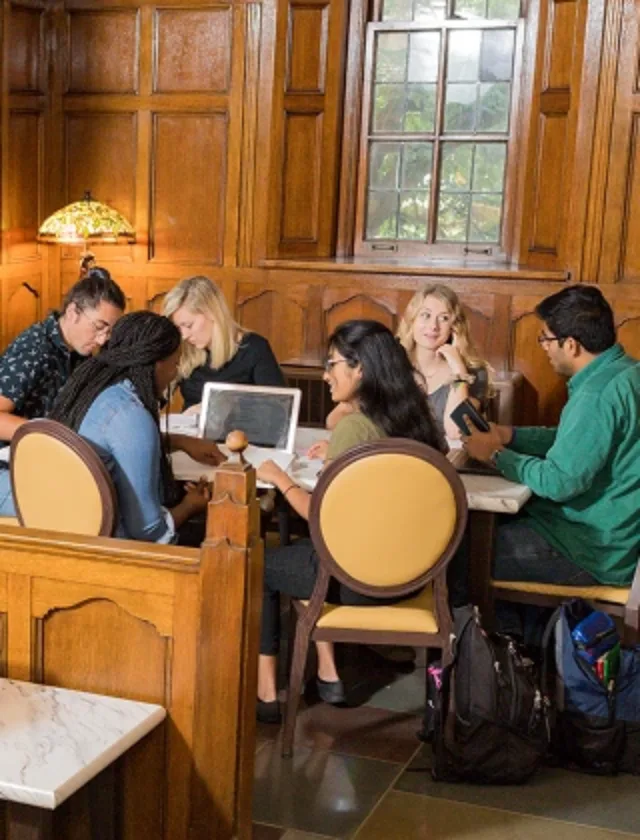 Student gather around a table in the lobby of the Michigan League.