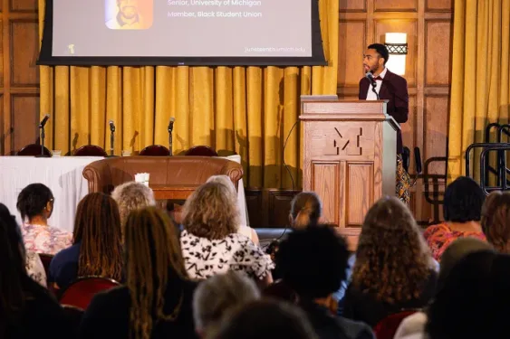 A student giving a presentation in front of a large group