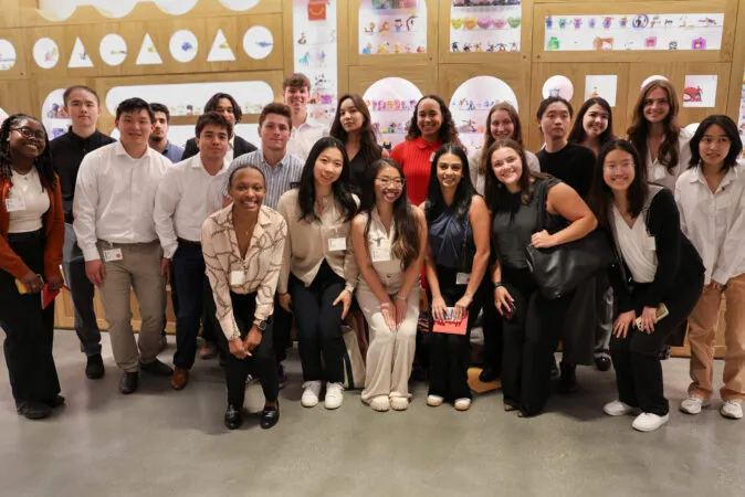 A large group of students gathered together. All are wearing professional clothing.