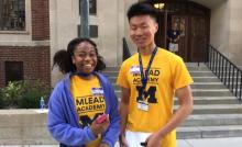 Two MLEAD students smile in front of a South Quad entrance