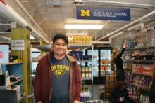 Reza (Ray) Azizan standing in The Maize and Blue Cupboard. 