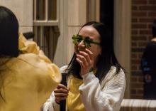 A student wearing clover glasses laughing while at a U-M St.Patrick's Day event.